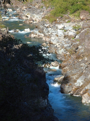 [Only a small portion of the image is in shade. The rest is in full sun showing how the rocks in the river create turbulence.]